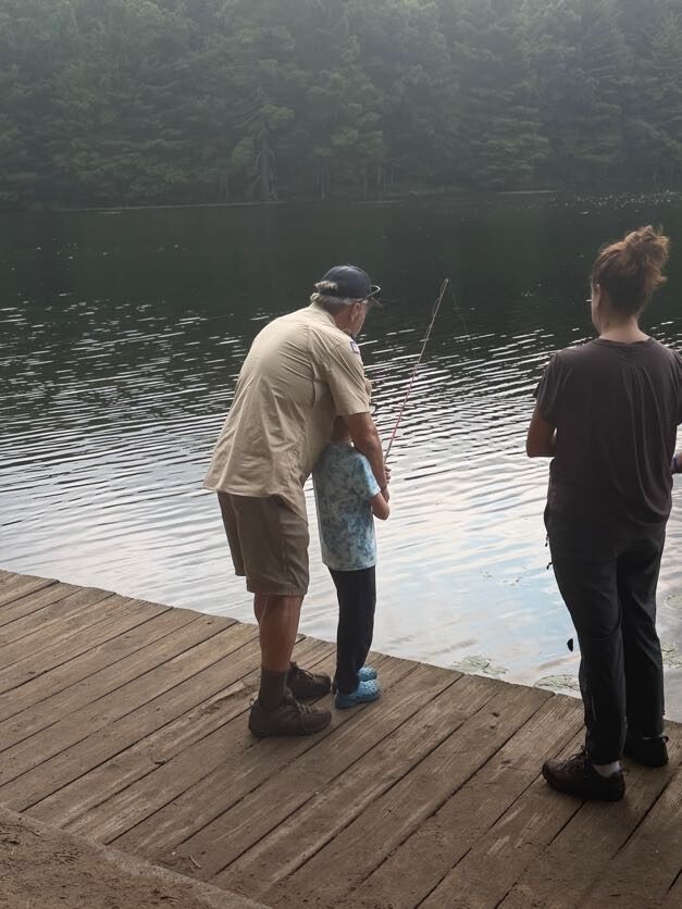 Adult leader supervising a Scout beside the lake